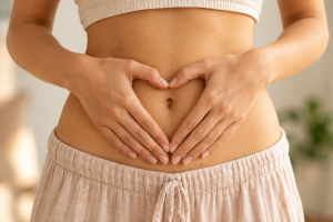 Digestion et santé : ventre de femme avec les mains en cœur autour du nombril